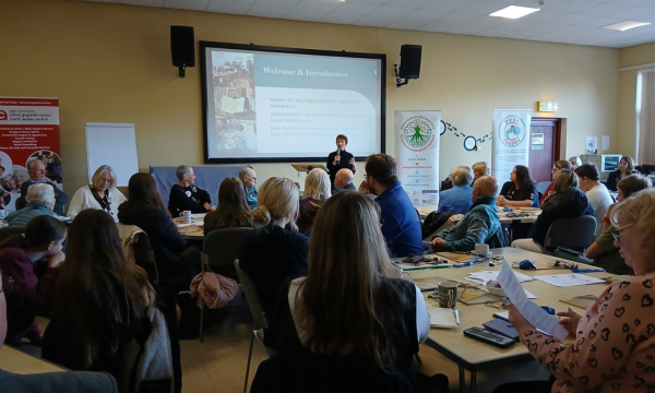 Comisiynydd Pobl Hŷn Cymru, Rhian-Bowen Davies, yn rhoi araith yng Nghanolfan Gymunedol Eirianfa. // Older People's Commissioner for Wales, Rhian-Bowen Davies, giving a speech at Eirianfa Community Centre.