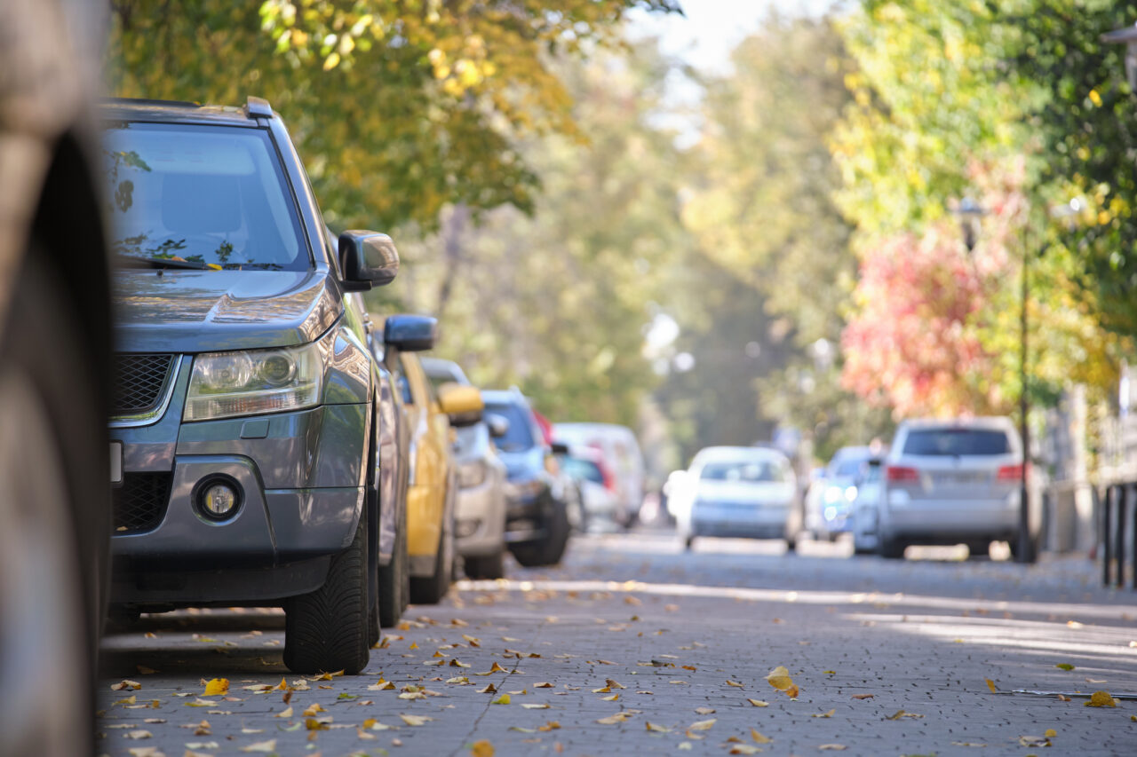Delwedd o nifer o geir wedi'u parcio ar y stryd. / Image of several cars parked on a street.