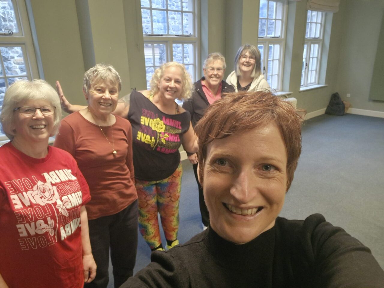 Comisiynydd Pobl Hŷn Cymru, yn y llun ochr yn ochr â phum aelod o Ddosbarth Aur Zumba Heneiddio'n Dda Dongellau. // Older People's Commissioner for Wales, pictured alongside five members of the Ageing Well Dongellau Zumba Gold Class.