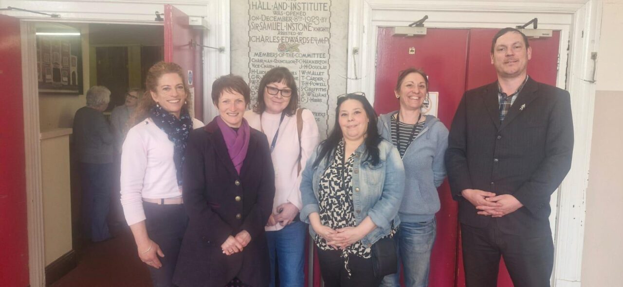 Comisiynydd Pobl Hŷn Cymru, Rhian Bowen-Davies (yr ail o'r chwith), yn y llun ochr yn ochr ag aelodau o Inside Out Cymru yn Neuadd a Sefydliad y Gweithwyr, Bedwas. // Older People's Commissioner for Wales, Rhian Bowen-Davies (second from left), pictured alongside members of Inside Out Cymru at Bedwas Workmen's Hall and Institute.