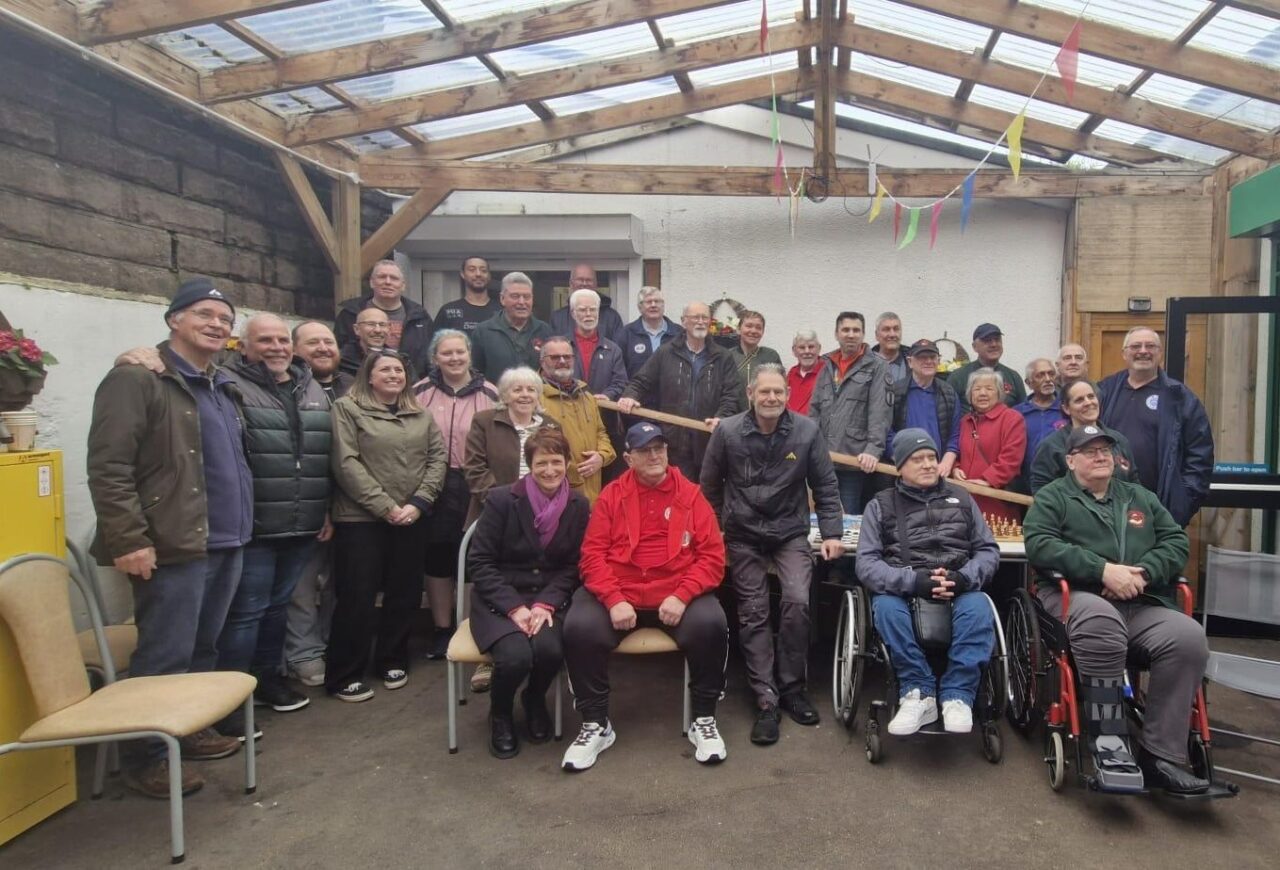 Comisiynydd Pobl Hŷn Cymru, Rhian Bowen-Davies (canol chwith), yn y llun ochr yn ochr ag aelodau Dusty Shed, y tu mewn i'w hystafell gwaith coed. // Older People's Commissioner for Wales, Rhian Bowen-Davies (centre left), pictured alongside members of Dusty Shed, inside their woodworking room.